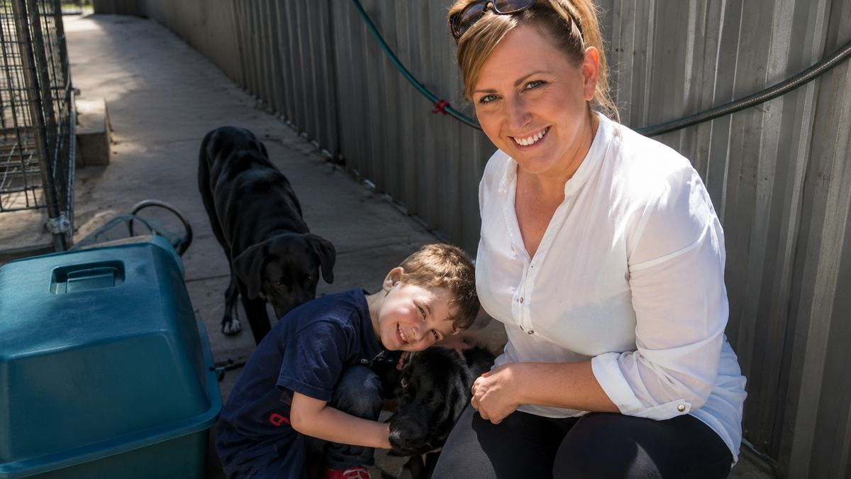 Lindsey Church, founder of Penny's Ark, on the ground with rescue dogs.